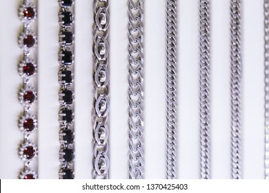 Luxury Silver Bracelets With Precious Stones Arranged In Lines In The Shop Window Of The Jewelry Store. Display Case With A White Background.