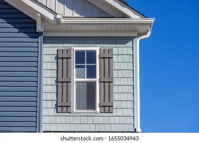 Luxury Single Family Home Natural Wood Look Rough Shake Finish Vinyl Bermuda Blue Shake And Shingle, Pacific Blue Horizontal Siding, Double Pane Window With Dark Shutters, Snow Trim, Beaded Corner