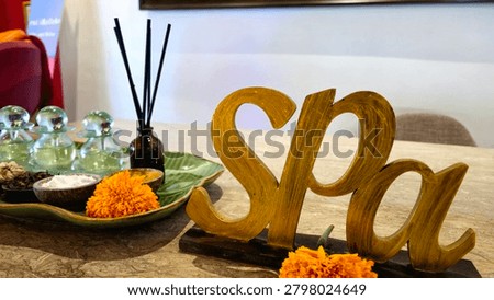 Luxury spa display featuring aromatic spices, diffuser reeds, decorative glass bottles, cinnamon sticks, and wellness ingredients arranged on a tropical leaf-shaped tray.