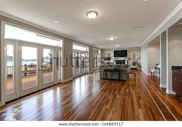 Luxury\
spacious family room interior with wall of glass doors leading out\
to spacious deck and facing the lake, polished hardwood floor and\
cozy sitting area with fireplace . Northwest,\
USA