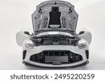 Luxury sport car with open engine in a white studio close up