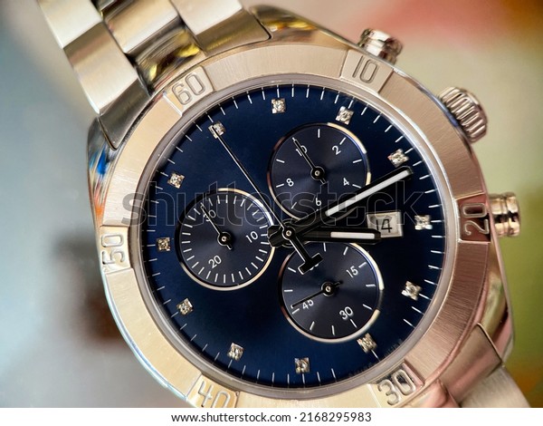 Luxury stainless steel watch with chronograph,\
dark blue dial and metal bracelet close-up. Macrophotography of\
watch details