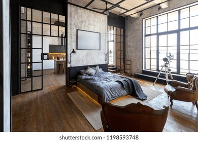 luxury studio apartment with a free layout in a loft style in dark colors. Stylish modern kitchen area with an island, cozy bedroom area with fireplace and personal gym - Shutterstock ID 1198593748