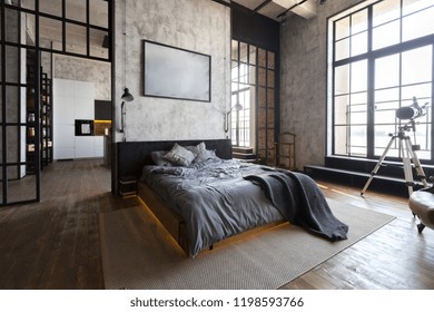 luxury studio apartment with a free layout in a loft style in dark colors. Stylish modern kitchen area with an island, cozy bedroom area with fireplace and personal gym - Shutterstock ID 1198593766