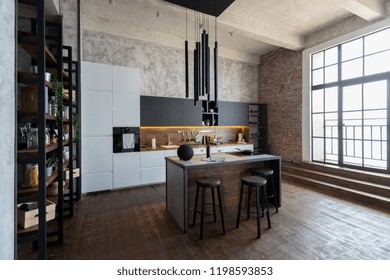 luxury studio apartment with a free layout in a loft style in dark colors. Stylish modern kitchen area with an island, cozy bedroom area with fireplace and personal gym - Shutterstock ID 1198593853