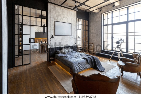 luxury studio apartment with a\
free layout in a loft style in dark colors. Stylish modern kitchen\
area with an island, cozy bedroom area with fireplace and personal\
gym