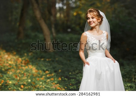 luxury stylish young bride on the background  spring sunny green forest