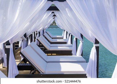 Luxury Sunbeds with White Curtains  Over the Sea.Summer Holiday Concept