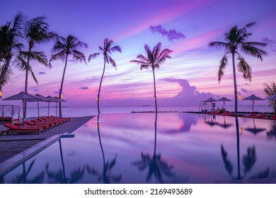 Luxury sunset over infinity pool in a summer beachfront hotel resort at beautiful tropical landscape. Tranquil beach holiday vacation background. Amazing island sunset beach view, palms swimming pool - Powered by Shutterstock