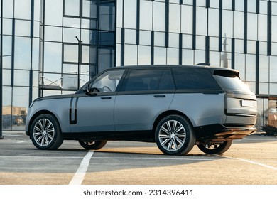 Luxury SUV car parked against a background of glass building
