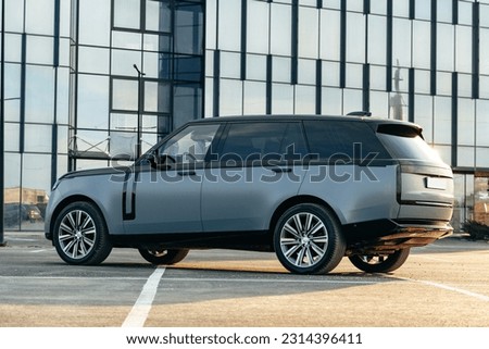 Luxury SUV car parked against a background of glass building