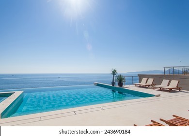 Luxury swimming pool and blue water at the resort with beautiful sea view.  - Powered by Shutterstock