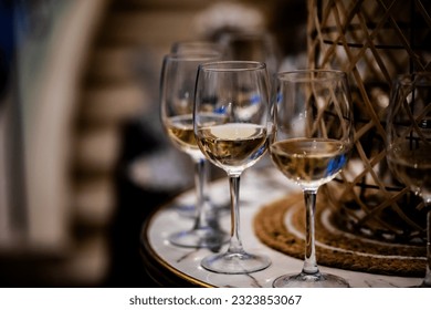Luxury table settings for fine dining with and glassware, pouring wine to glass. Beautiful blurred background. Preparation for holiday wedding. Fancy luxury restaurant.