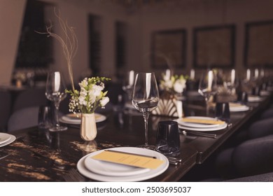luxury tableware beautiful table setting in restaurant. banquette luxury arrangement plates and glasses. Glasses, forks, knives, napkins and decorative flower on a dark old brown wooden table.