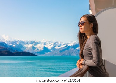 Luxury travel Alaska cruise vacation woman relaxing on balcony enjoying view of mountains and nature landscape. Asian girl sunglasses tourist. - Powered by Shutterstock