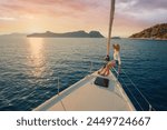 Luxury travel on the yacht. Young woman on boat deck sailing the sea. Yachting on sunset.
