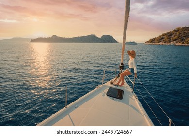 Luxury travel on the yacht. Young woman on boat deck sailing the sea. Yachting on sunset. - Powered by Shutterstock