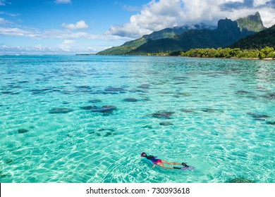 Luxury Travel Vacation Tourist Woman Snorkeling In Tahiti Ocean, Moorea Island, French Polynesia. Snorkel Swim Girl Swimming In Crystalline Waters And Coral Reefs.