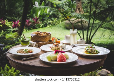 Luxury Tropical Breakfast With Fruits And Pancakes In Hotel In Ubud, Bali, Indonesia With View On Tropical Green Garden