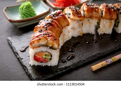 The Luxury Unagi Rol roll with a large slice of smoked salmon in a sauce, with fresh salmon, tuna, Philadelphia cheese, tobiko caviar, cucumber and avocado. Sushi menu. Japanese food. Asian Food - Shutterstock ID 1113014504