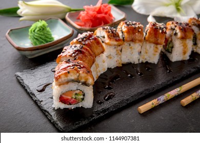 The Luxury Unagi Rol roll with a large slice of smoked salmon in a sauce, with fresh salmon, tuna, Philadelphia cheese, tobiko caviar, cucumber and avocado. Sushi menu. Japanese food. Asian Food - Shutterstock ID 1144907381