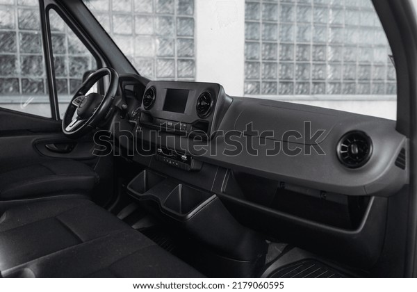 Luxury van driver seats with dashboard,\
multimedia control screen, and steering wheel. The cockpit of a\
modern luxury minivan