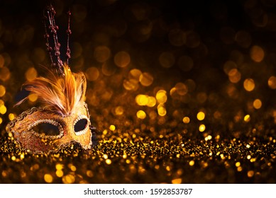 Luxury Venetian Mask On Dark Godlen Bokeh Background. New Year And Christmas Party Celebration Design Banner. Carnival Masquerade Fantasy Costume Ball.