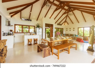 Luxury villa living room with kitchen interior. White walls and wooden furniture