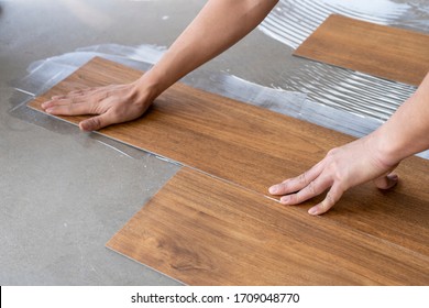 luxury vinyl floor tile collection : step of Vinyl installation by laying vinyl sheet tiles on notched trowel glue area , floor decorate business  - Shutterstock ID 1709048770