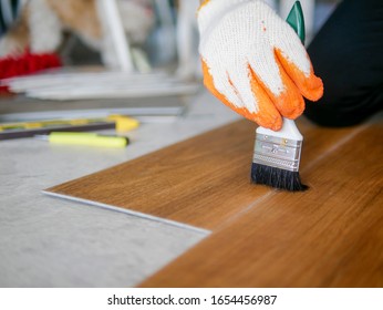 Luxury Vinyl Floor Tiles  Collection : Contractor Working On Renovation Site By Brush Cleaning Tools While Laying Each Vinyl Sheet On Floor