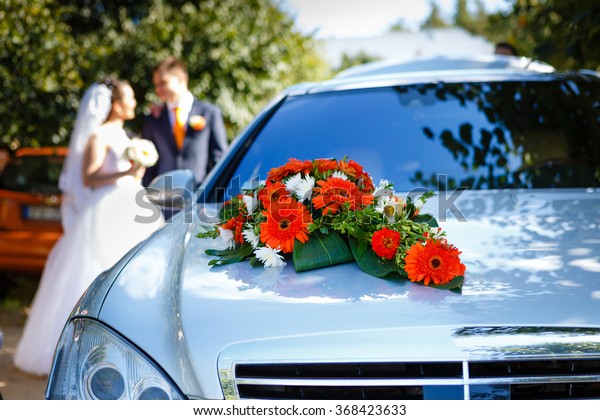 Luxury wedding car decorated with flowers,\
bride and groom on wedding car\
background