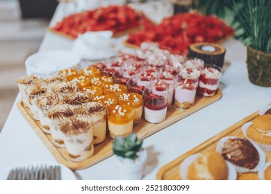 luxury wedding catering, table with modern desserts, cupcakes, sweets with fruits. delicious candy bar at expensive wedding reception. space for text. shower. holiday celebration - Powered by Shutterstock