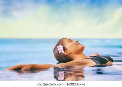 Luxury Wellness Spa Resort Asian Woman Relaxing Swimming In Infinity Pool At Hotel. Caribbean Tropical Travel Vacation Getaway.