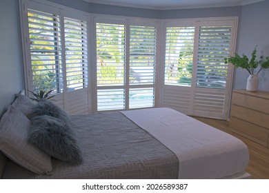Luxury white indoor plantation shutters in bedroom - selective focus	