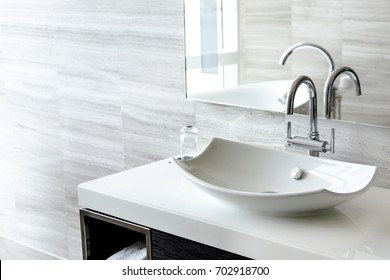 Luxury white porcelain sink on a bathroom table - Shutterstock ID 702918700