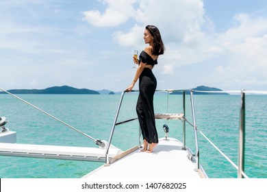 Luxury Woman In Evening Black Dress Drinking Champagne On The Deck Of A Boat 