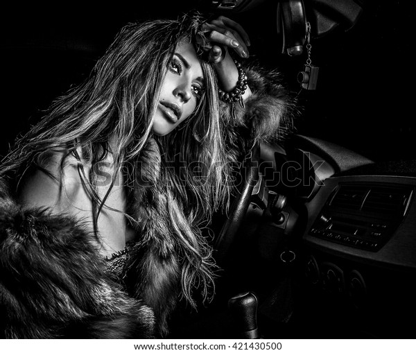 Luxury woman in\
sport car. Black-white\
photo.