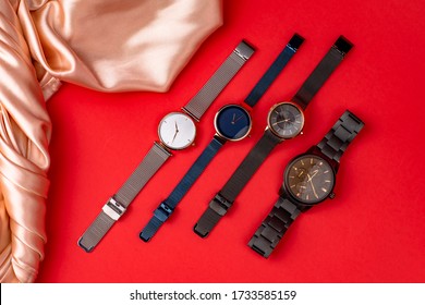 Luxury Wrist Watches On Red Color Background. Gold Watch. Women And Man Watches. Female And Male Watches. Closeup. Fashion Accessory