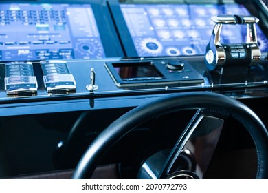Luxury yacht cockpit with dashboard, steering wheel and acceleration levers.