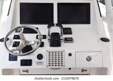 Luxury yacht control panel with steering wheel, gear levers, navigation devices, control buttons and on-board computer.