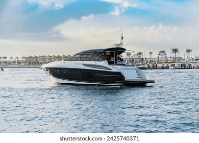 A luxury yacht in Dubai with skyline and sky scrapers - Powered by Shutterstock