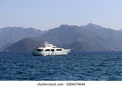 Luxury Yacht Sailing In Aegean Sea, Side View. Modern Boat On Misty Mountains Background