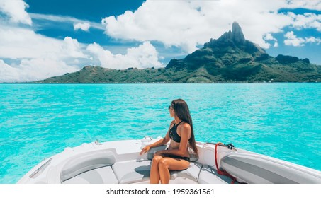 Luxury Yacht Travel Woman Enjoying Ride On High End Speed Boat On Summer Vacation. Elegant Black Bikini, Long Hair And Sun Tanned Body. By Famous Mount Otemanu, Bora Bora, French Polynesia, Tahiti