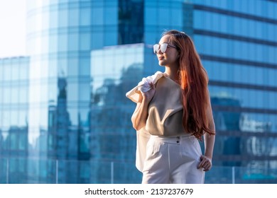 Luxury Young Asian CEO Woman Entrepreneur Standing On The Rooftop Looking Into The Sun With Skyscraper And Cityscape On The Background