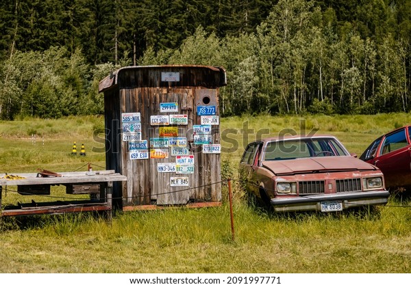 Luzna, Czech Republic, 31 July 2021:  Vintage old\
historic cars displayed at Classic Automobile Museum of American\
veterans JK Classics, old rusty cars in grass at dump, Route 66,\
license plates