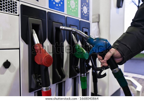 Lviv, Ukraine, 9 march 2020. A gas station
worker holds fuel-pistol at gas
station.