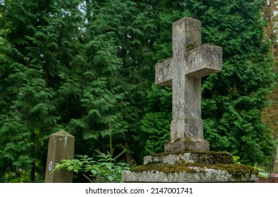 LVIV, UKRAINE - August 23, 2021: A View From Lychakiv Cemetery Showing An Old Stone Cross On A Grave.