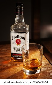 LVIV, UKRAINE - DECEMBER 04: Bottle of Jim Beam whisky and glass on wooden shelf on December 04, 2017 in Lviv