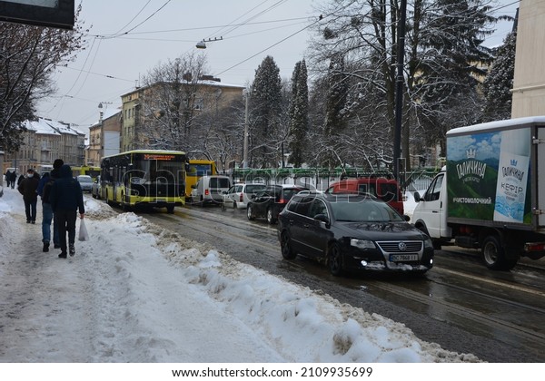 Lviv.\
Ukraine. January 2022.Snow covered cars after snowfall at winter\
day.Vehicles covered with snow in a winter blizzard in the parking\
lot. Snow-covered roads and streets of the\
city.