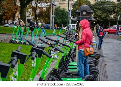 Lviv. Ukraine. July, 2021.Trendy Fashinable Teenager Girls Riding Public Rental Electric Scooters In Urban City Environment. New Eco-friendly Modern Public City Transport